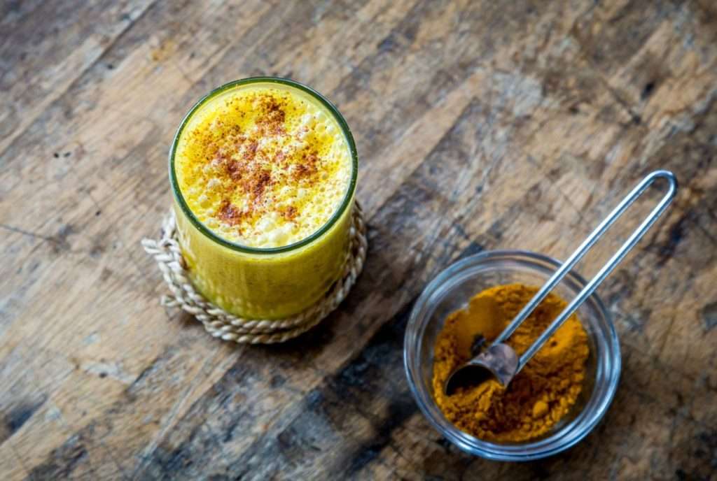 Come sconfiggere l'ansia primaverile naturalmente? Con un bicchiere di goldem milk come quello dell'immagine con accanto una ciotolina di vetro di profumata curcuma. Il tutto su un tavolo di legno grezzo