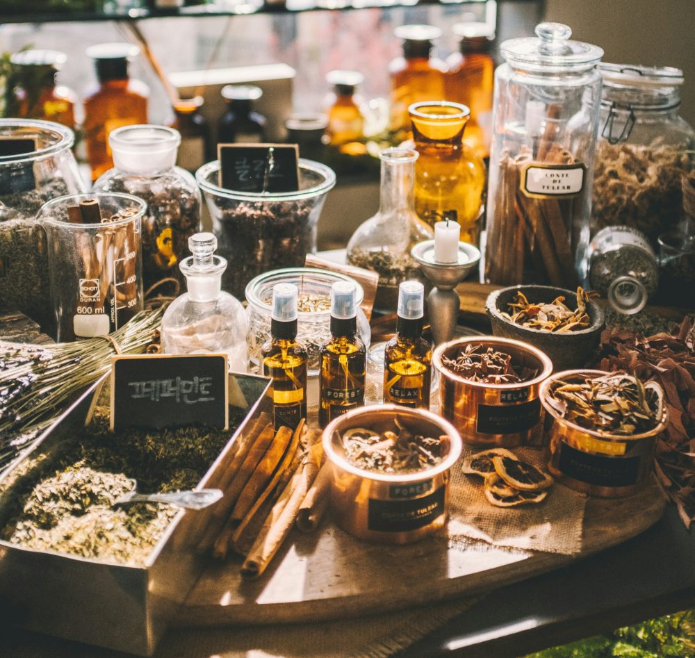 Tavolo da erborista con boccette, vasi, erbe e preparati per combattere i dolori articolari